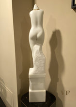 Laden Sie das Bild in den Galerie-Viewer, View of back side White marble sculpture of a female torso on a pedestal against a beige wall.
