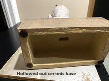 Carica l'immagine nel visualizzatore di Gallery, Hollowed out ceramic base on a table with text label showing that the sculpture is hollow and has soft cushion pads on the bottom to not scratch a tabletop when displaying the art there.
