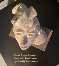 Carica l'immagine nel visualizzatore di Gallery, Ceramic sculpture of a boy's upturned face with a horse on his head, bird's eye view, on a black background, labeled 'View from Above, Ceramic Sculpture by Vasily Fedorouk'.
