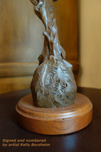 Load image into Gallery viewer, detail of the round cherry wood base for the bronze sculpture of man and hawk.  Here you see the artist K. Borsheim&#39;s signature, and the number in the limited edition bronze figure sculpture 
