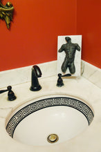 Laden Sie das Bild in den Galerie-Viewer, The black patina bronze nude male torso artwork is a dramatic decor addition to this stylish bathroom countertop with black spigot and a sink with a geometric border on the inside edge.  red walls offset the art!  
