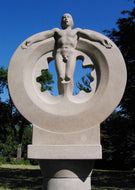A geometric sculpture in stone is contrasted by the figure of a standing man with his arms extended almost horizontally.  Lovely outdoor sculpture by Vasily Fedorouk