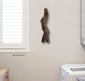 Nude sculpture also enhances the room where one washes clothes!  Shown here is a female torso bronze sculpture mounted on the wall above the washing machine.