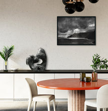 Load image into Gallery viewer, This dining space with a counter along the back wall hosts a stone carving in black and white marble of abstracted manta rays, Encounter.  Above and to the right of the sculpture is a charcoal drawing of light shining through dark clouds onto a rugged coastline in Italy.  Art makes everything more personal and enjoyable.
