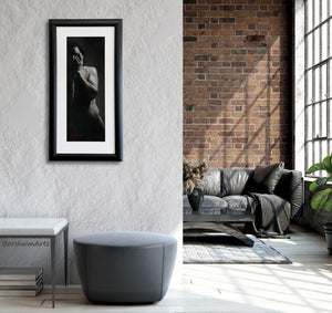 This tall narrow black and white figure drawing of a man with his hands over his face looks great in a modern loft apartment with grey furniture and nearby a red brick wall.  Original framed art by Kelly Borsheim