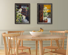 Laden Sie das Bild in den Galerie-Viewer, This pair or original floral painting of jasmine flowers outside an Italian home look great in this contemporary dining room of light wood table and chairs against a pale green wall. The yellows in the paintings are a perfect compliment to the yellow in the bananas and fruit in the bowl on the table. 
