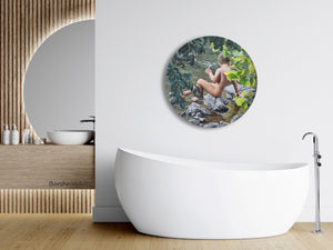 Lollipop, a round painting celebrating the innocence of youth, a young boy sits on a rock looking into a river.   His nude figure is surrounded by tree leaves, increasing his alone time in nature.  Shown here with an elegant bathroom featuring a round window.