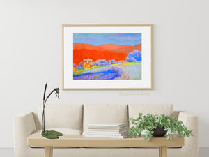 Framed with a white mat and thin light wood frame, Orange Tuscan Hills pastel painting original becomes a statement piece of art, certain to grab attention.  Shown on the coffee table is the bronze tabletop sculpture Cattails and Frog Legs.  Both artworks by Kelly Borsheim