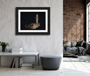 Palazzo Vecchio at Night, a pastel drawing on black paper inspired by the City Hall architecture in Florence, Italy, is shown here is mockup wide, dark frame with white mat. the art is hung in a loft apartment for a blend of old and new.