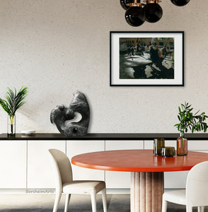 A print of Santo Spirito Shadows is framed and matted and hanging on the wall in a casual restaurant dining area.  The dark shadows in this print of a charcoal drawing play well with the black and orange-red dining room decor.