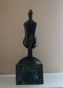 Back view, sleek lines, Pregnancy, a female pregnant mamma squatting with legs together in a graceful, elegant pose, bronze figure statue, mounted on a green marble base, tabletop sculpture by Vasily Fedorouk, Ukrainian - American sculptor artist