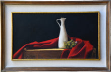 Laden Sie das Bild in den Galerie-Viewer, Green olives sit in a transparent bowl next to a tall thin white karaf containing olive oil.  A red cloth surrounds them as they sit on a warm wood box for used for wine transport.
