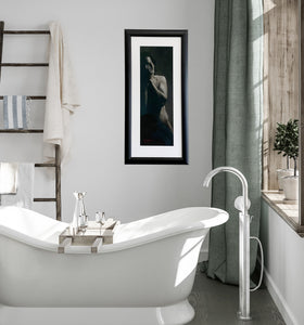 Enough a charcoal drawing of a standing man covering his face with his hands, black and white framed drawing hung in an elegant bathroom of soft greys, sage green, and a stylish white bathtub.  