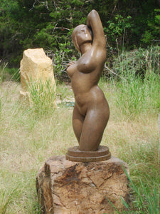 The brown granite-like patina on this outdoor garden bronze sculpture of a nude woman Gemini looks wonderful surrounded by green grasses and trees.