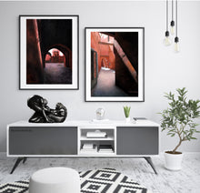Cargar imagen en el visor de la galería, Helping Hands, black marble sculpture of couple man helping woman come to her feet, were dancers, stylized Infinity symbol, set in a living room scene with two Borsheim pastel drawings of Morocco, Marrakesh. lovely home decor wall art
