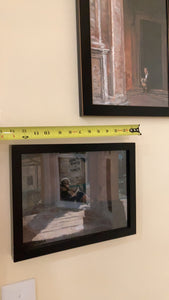 Libri Riviste e Fumetti - girl reading small pastel painting hung on the wall.  A tape measure is shown above it to help you see the size.  Above is another framed artwork in pastels and charcoal by artist Kelly Borsheim titled "Pensive in Bologna." 