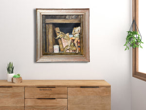 Framed still life painting of old puppet and books as shown on a wall over a dresser.  Vintage Italian distressed wood frame