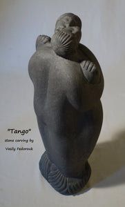 Tango a 2-foot tall stone carving in Alaskan marble of a closely dancing couple.  As he embraces her, she nibbles on his ear.  The figures are modern, abstracted or better, designed with minalist features and intertwined fingers.  A romantic sculpture, carved by Ukrainian-American artist and sculptor Vasily Fedorouk.  Vertical, standing figures.