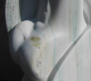 Detail of the pale green yellow gems inside the white Colorado Yule Marble sculpture Yin Yang by Kelly Borsheim