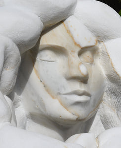 Detail of face from left Marble sculpture portrait of a serene woman with flowing locks of wavy hair Serenity marble art