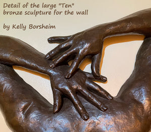 detail of bronze bas-relief figure sculpture to see the bronzy color of the patina, as well as the subtle textures in the nude figure wall sculpture of the back of a woman with Bob Fosse hands spread together over her shoulders. Title is "Ten" for her beauty and the number of digits on both hands. Artwork by artist Kelly Borsheim, limited edition bronze