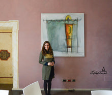 Laden Sie das Bild in den Galerie-Viewer, The Serbian born, Italy-based artist Dragana Adamov smiles in front of her large 150 x 150 cm oil painting titled Aphrodite.  She is also wearing her own sewn creations. 

