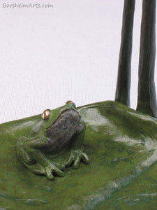 Detail of sitting frog looking up tabletop aquatic bronze sculpture, Cattails and Frog Legs Lily Pad Green Art