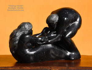 Helping Hands by Kelly Borsheim Couple Art Carved from a black marble called Bardiglio from Italy, this sculpture depicts a man bending over forward to help a seated woman stand up. Her hands reach up towards his bearded face, but it is the moment before she is close enough to reach him. 