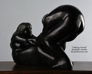 Her face and long hair Helping Hands by Kelly Borsheim Couple Art Carved from a black marble called Bardiglio from Italy, this sculpture depicts a man bending over forward to help a seated woman stand up.  Her hands reach up towards his bearded face, but it is the moment before she is close enough to reach him. 
