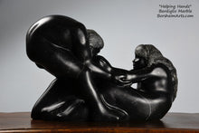 Laden Sie das Bild in den Galerie-Viewer, Helping Hands by Kelly Borsheim Couple Art Carved from a black marble called Bardiglio from Italy, this sculpture depicts a man bending over forward to help a seated woman stand up.  Her hands reach up towards his bearded face, but it is the moment before she is close enough to reach him. 
