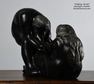His face, hair and beard and her long hair flowing down the back Helping Hands by Kelly Borsheim Couple Art Carved from a black marble called Bardiglio from Italy, this sculpture depicts a man bending over forward to help a seated woman stand up.  Her hands reach up towards his bearded face, but it is the moment before she is close enough to reach him. 