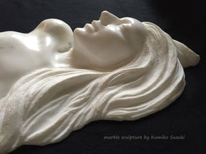 Detail white marble portrait sculpture of a woman with long flowing hair by Japanese artist Kumiko Suzuki