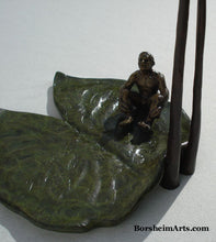 Load image into Gallery viewer, Looking down on the little bronze man sitting on a lily pad as he looks skyward.  bronze sculpture by Kelly Borsheim
