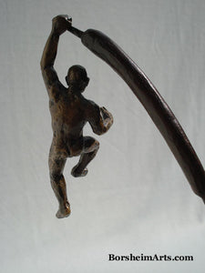 The Unwritten future... a man hangs on with one arm while his body swings on the tip of a cattail.  bronze sculpture that contemplates choices