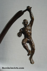 Nude man swings precariously in this bronze sculpture about choices and decisions.  Will he fall or save himself in this situation?