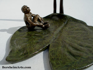 patina close up of green lily pad and little bronze figure man.  Sculpture by Kelly Borsheim Borsheim Arts Studio.