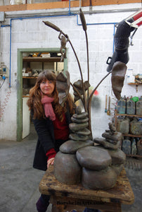 Artist Kelly Borsheim with her sculpture Rock Towers and Frogs Bronze Outdoor Garden Sculpture